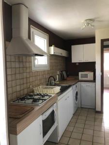 a kitchen with white cabinets and a stove top oven at Le ry de pouzioux in Chauvigny
