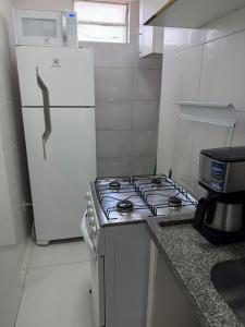 a kitchen with a white stove and a white refrigerator at Apartamento no centro de Cuiaba até 3 pessoas in Cuiabá