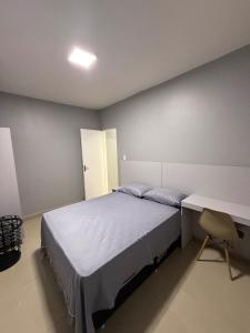a bedroom with a large bed and a desk at Apartamento no centro de Cuiaba até 3 pessoas in Cuiabá