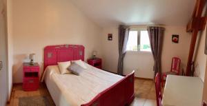 a bedroom with a red bed and a window at Les trois rivières in Persac +7 photos