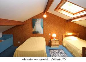 a bedroom with two beds and a skylight at Les trois rivières in Persac