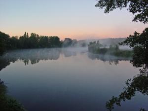 a misty lake in the middle of a forest at Les trois rivières in Persac