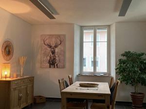 a dining room with a table and a picture of a deer at Appartement Atelier in Le Noirmont