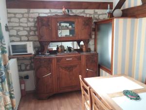 a kitchen with a wooden cabinet with a microwave at Le grenier d'alice in Thurageau