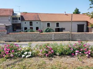 a retaining wall with flowers in front of a house at Le grenier d'alice in Thurageau