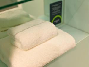 two towels are sitting on a shelf in a bathroom at B&B HOTEL Birmingham Centre in Birmingham