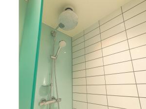 a shower in a bathroom with a blue wall at B&B HOTEL Birmingham Centre in Birmingham