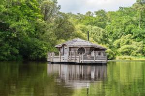 a house on a dock in the middle of a lake at Le Moulin de Trévelo in Caden