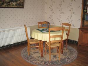 a dining room with a table and four chairs at La maisons des tilleuls in Thurageau
