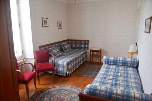 a bedroom with a bed and a couch and chairs at La maisons des tilleuls in Thurageau