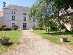 a house with a dirt road in front of it at La maisons des tilleuls in Thurageau +13 photos