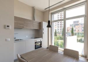 a kitchen with a wooden table and a large window at Open Space - Garden & Jacuzzi in Milan