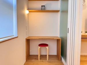 a stool sitting under a desk in a room at ura アルコバレーノ奉還町 in Okayama