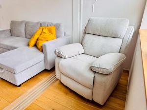 a living room with a couch and a chair at ura アルコバレーノ奉還町 in Okayama
