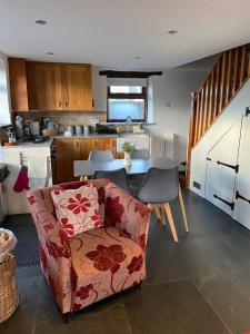 a living room with a couch and a kitchen at LYDONIA BARN in Lydford