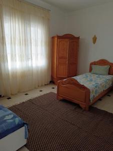 a bedroom with a bed and a dresser in it at Salmane Villa in Nabeul +8 photos