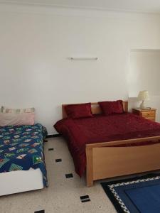 a bedroom with a bed with a red bedspread at Salmane Villa in Nabeul