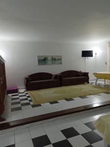 a living room with a couch and a checkered floor at Salmane Villa in Nabeul