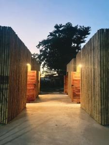 a wooden fence with a tree in the background at Homey Bamboo Lanta in Ban Ai Dao