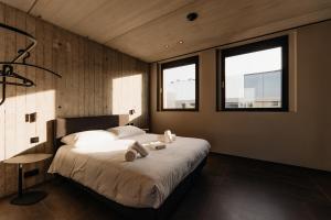 a bedroom with a large bed with two towels on it at Coliving - Bord de Meuse - L'échappée Mosane in Oupeye +63 photos