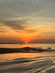 a sunset on the beach with the sun setting at Homey Bamboo Lanta in Ban Ai Dao +5 photos