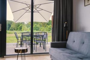 a living room with a couch and a table and chairs at Morski Las in Ustronie Morskie