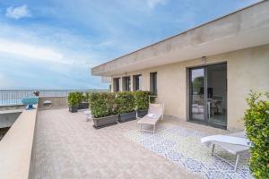 a patio with chairs and tables on a building at Aurora View Resort - Boutique Suites in Mascali