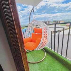 an orange chair in a hanging chair on a balcony at Bethany Cushy Home Ltd in Kisii