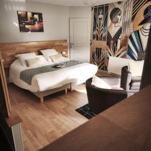 a bedroom with a bed and a couch and a chair at Maison Alfred et Agatha in Pleudihen-sur-Rance