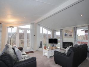 a living room with two couches and a television at Iona Lodge in Fort William