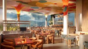a restaurant with tables and chairs and a large window at Hotel Londres in Caracas