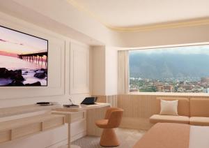 a living room with a desk and a large window at Hotel Londres in Caracas