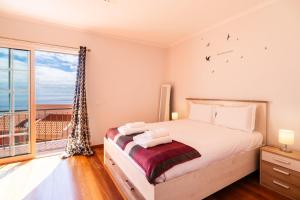 a bedroom with a bed and a large window at GuestReady - Alluring island retreat in Santa Cruz