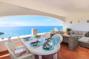 a living room with a table and a view of the ocean at UHC CasasBlancas Family Complex in Salou