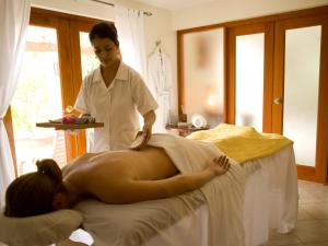 a woman getting a massage from a masseur at Ka'ana Resort & Spa in San Ignacio