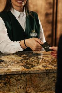 a woman is holding a card in her hands at MontiSio Boutique Hotel in Gudauri