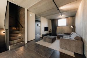 a living room with a couch and a chair and stairs at Coliving - Bord de Meuse - L'échappée Mosane in Oupeye