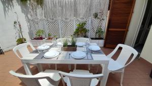 a white table with chairs and plates and glasses at La casa accanto in Rio nellʼElba +25 photos