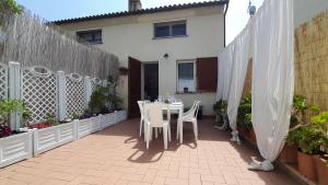 a patio with a table and chairs and a white fence at La casa accanto in Rio nellʼElba