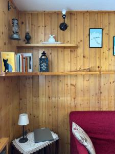 a room with a red couch and a table with a lamp at Casa Chigi in Valdidentro