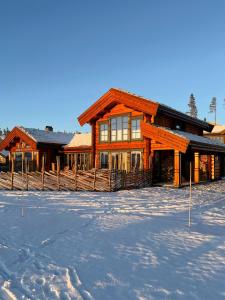 a large wooden house in the snow with snow at Log Cabin With Views Over Turufjell in Flå