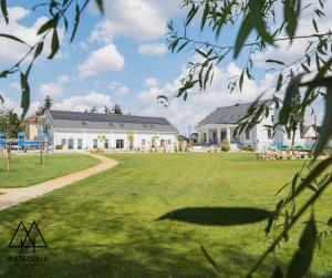 a large lawn in front of a house at Folwark Matecznik - Dworek in Sęzinko