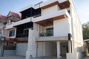 a white building with balconies on the side of it at Family Hostel in Chiang Rai
