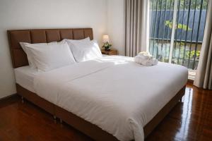 a bed with a teddy bear sitting on top of it at Family Hostel in Chiang Rai