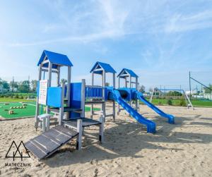 a playground with a slide in the sand at Folwark Matecznik - Dworek in Sęzinko