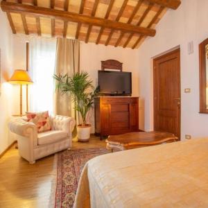 a bedroom with a bed and a couch and a tv at Terrazza panoramica, 3 camere e 3 bagni in Collecorvino