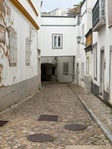 an alley in an old town with buildings at Arcada House Tavira in Tavira +29 photos