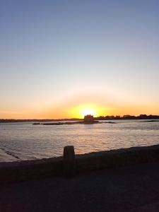 a sunset over a body of water with the sun setting at Chambre d'Hôtes à Bopérec in Nostang +3 photos