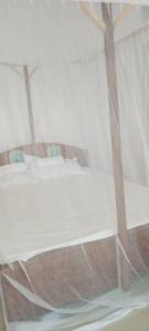 a room with a white bed with a window at Upole HOTEL in Nungwi