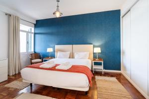 a bedroom with a large bed with a blue wall at Lido Mar - Hotels area in Funchal